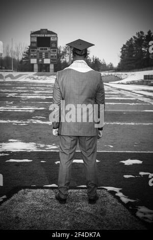 EAU VIVE, WI. USA DEC 19, 2020: APRÈS UNE CÉRÉMONIE DE REMISE DE DIPLÔMES VIRTUELLE, UN JEUNE AFRICAIN AMÉRICAIN REGARDE À TRAVERS LE FOOTBALL FEILD OÙ IL A JOUÉ. Banque D'Images