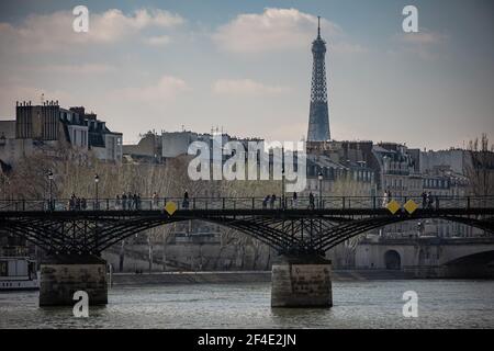 Paris, France. 20 mars 2021. Les gens marchent sur le pont du Pont des Arts à Paris, France, le 20 mars 2021. Le Premier ministre français Jean Castex a annoncé jeudi de nouvelles mesures massives pour réduire la COVID-19 dans les 16 régions les plus touchées du pays, y compris Paris. A partir de vendredi minuit, environ 18 millions de Français dans des régions telles que Paris, hauts-de-France dans le nord ainsi que les Alpes-Maritimes sur la Méditerranée devraient rester chez eux, a annoncé Castex lors d'un briefing de presse sur la situation épidémique. Crédit: Aurélien Morissard/Xinhua/Alay Live News Banque D'Images