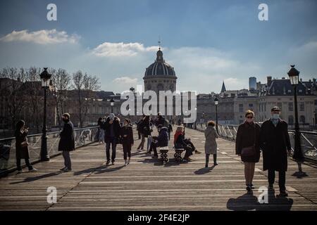 Paris, France. 20 mars 2021. Les gens marchent sur le pont du Pont des Arts à Paris, France, le 20 mars 2021. Le Premier ministre français Jean Castex a annoncé jeudi de nouvelles mesures massives pour réduire la COVID-19 dans les 16 régions les plus touchées du pays, y compris Paris. A partir de vendredi minuit, environ 18 millions de Français dans des régions telles que Paris, hauts-de-France dans le nord ainsi que les Alpes-Maritimes sur la Méditerranée devraient rester chez eux, a annoncé Castex lors d'un briefing de presse sur la situation épidémique. Crédit: Aurélien Morissard/Xinhua/Alay Live News Banque D'Images