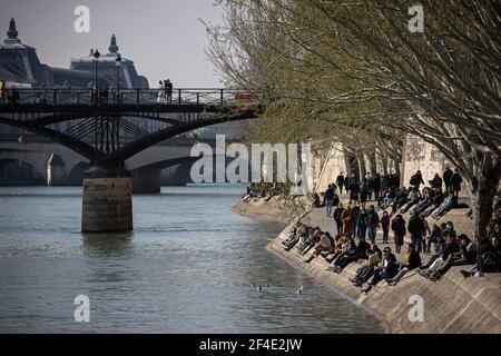 Paris, France. 20 mars 2021. Les gens profitent du soleil sur la rive de la Seine à Paris, en France, le 20 mars 2021. Le Premier ministre français Jean Castex a annoncé jeudi de nouvelles mesures massives pour réduire la COVID-19 dans les 16 régions les plus touchées du pays, y compris Paris. A partir de vendredi minuit, environ 18 millions de Français dans des régions telles que Paris, hauts-de-France dans le nord ainsi que les Alpes-Maritimes sur la Méditerranée devraient rester chez eux, a annoncé Castex lors d'un briefing de presse sur la situation épidémique. Crédit: Aurélien Morissard/Xinhua/Alay Live News Banque D'Images