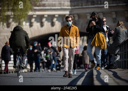 Paris, France. 20 mars 2021. Les gens marchent le long de la rive de Seine à Paris, France, le 20 mars 2021. Le Premier ministre français Jean Castex a annoncé jeudi de nouvelles mesures massives pour réduire la COVID-19 dans les 16 régions les plus touchées du pays, y compris Paris. A partir de vendredi minuit, environ 18 millions de Français dans des régions telles que Paris, hauts-de-France dans le nord ainsi que les Alpes-Maritimes sur la Méditerranée devraient rester chez eux, a annoncé Castex lors d'un briefing de presse sur la situation épidémique. Crédit: Aurélien Morissard/Xinhua/Alay Live News Banque D'Images