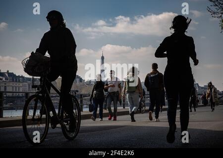 Paris, France. 20 mars 2021. Les gens marchent le long de la rive de Seine à Paris, France, le 20 mars 2021. Le Premier ministre français Jean Castex a annoncé jeudi de nouvelles mesures massives pour réduire la COVID-19 dans les 16 régions les plus touchées du pays, y compris Paris. A partir de vendredi minuit, environ 18 millions de Français dans des régions telles que Paris, hauts-de-France dans le nord ainsi que les Alpes-Maritimes sur la Méditerranée devraient rester chez eux, a annoncé Castex lors d'un briefing de presse sur la situation épidémique. Crédit: Aurélien Morissard/Xinhua/Alay Live News Banque D'Images