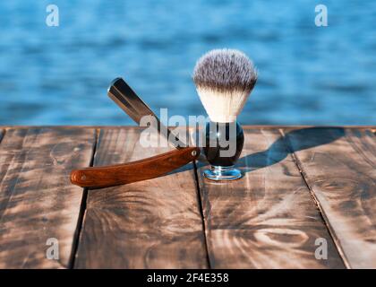 rasoir et brosse sur une jetée en bois sur le bord de mer le matin Banque D'Images