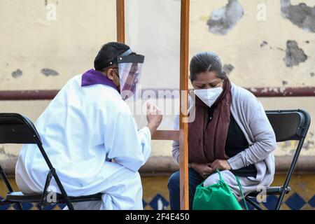 TOLUCA, MEXIQUE MARS 18: Un prêtre, écoute une confession d'un fidèle pendant la confessionnelle extérieure au temple de Santa Veracruz, comme protocoles de sécurité pour prévenir de nouvelles infections Covid. Le 18 mars 2021 à Toluca, Mexique. Crédit : Amaresh V. Narro/Eyepix Group/The photo Access Banque D'Images