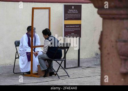 TOLUCA, MEXIQUE MARS 18: Un prêtre, écoute une confession d'un fidèle pendant la confessionnelle extérieure au temple de Santa Veracruz, comme protocoles de sécurité pour prévenir de nouvelles infections Covid. Le 18 mars 2021 à Toluca, Mexique. Crédit : Amaresh V. Narro/Eyepix Group/The photo Access Banque D'Images