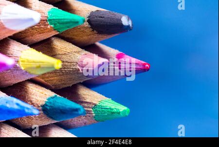 Super macro de pointes de crayon colorées en position horizontale avec arrière-plan bleu Banque D'Images