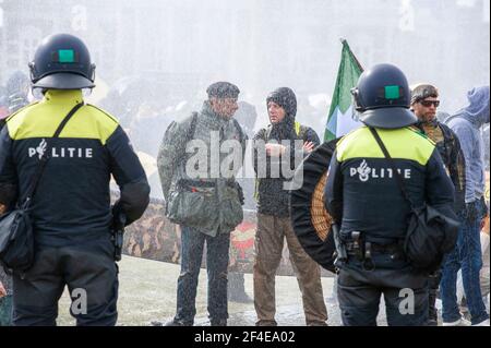 Museumplein, Amsterdam. Samedi 20 mars 2021. L'amour, la liberté, pas la dictature" était le principal chant de la manifestation d'aujourd'hui. Des centaines de personnes se sont rassemblées cet après-midi pour protester contre les mesures Corona ou Covid-19, elles n'ont pas été tenues à distance sociale et à peine un masque facial en vue. La manifestation illégale s'est terminée sur le Museumplein avec l'introduction de deux canons à eau après que de nombreuses annonces verbales de disperser ont été ignorées. La police a divisé le groupe estimé de 1400 personnes et les a escortés vers le quartier de Leidsekade à Amsterdam. Credit: Charles M Vella/Alay Live News Banque D'Images