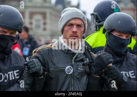 Museumplein, Amsterdam. Samedi 20 mars 2021. L'amour, la liberté, pas la dictature" était le principal chant de la manifestation d'aujourd'hui. Des centaines de personnes se sont rassemblées cet après-midi pour protester contre les mesures Corona ou Covid-19, elles n'ont pas été tenues à distance sociale et à peine un masque facial en vue. La manifestation illégale s'est terminée sur le Museumplein avec l'introduction de deux canons à eau après que de nombreuses annonces verbales de disperser ont été ignorées. La police a divisé le groupe estimé de 1400 personnes et les a escortés vers le quartier de Leidsekade à Amsterdam. Credit: Charles M Vella/Alay Live News Banque D'Images