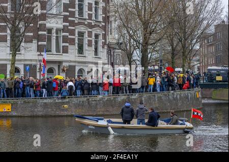 Museumplein, Amsterdam. Samedi 20 mars 2021. L'amour, la liberté, pas la dictature" était le principal chant de la manifestation d'aujourd'hui. Des centaines de personnes se sont rassemblées cet après-midi pour protester contre les mesures Corona ou Covid-19, elles n'ont pas été tenues à distance sociale et à peine un masque facial en vue. La manifestation illégale s'est terminée sur le Museumplein avec l'introduction de deux canons à eau après que de nombreuses annonces verbales de disperser ont été ignorées. La police a divisé le groupe estimé de 1400 personnes et les a escortés vers le quartier de Leidsekade à Amsterdam. Credit: Charles M Vella/Alay Live News Banque D'Images