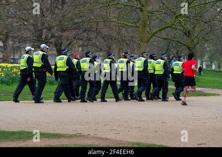 Londres, Royaume-Uni. 20 mars 2021. Un homme passe devant un groupe d'officiers de police à Hyde Park pendant le rassemblement mondial pour la liberté, qui était essentiellement pacifique.des militants et des personnes ont organisé une manifestation contre les restrictions actuelles liées à la maladie du coronavirus (COVID-19) dans un rassemblement mondial pour la liberté. Crédit : SOPA Images Limited/Alamy Live News Banque D'Images