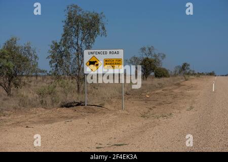 Panneau à côté d'une route de terre non clôturée et non scellée dans l'outback Queensland, Australie la route de conseil n'est pas clôturée et de surveiller le bétail. Banque D'Images