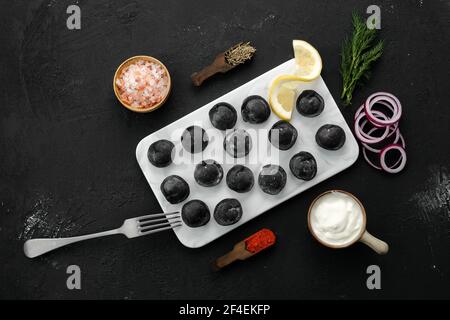 Boulettes noires avec bœuf et pâte à l'encre de seiches plaque de marbre Banque D'Images