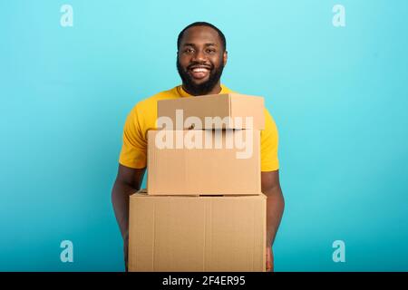 Happy boy reçoit un forfait de l'ordre de fabrication en ligne. Fond bleu. Banque D'Images