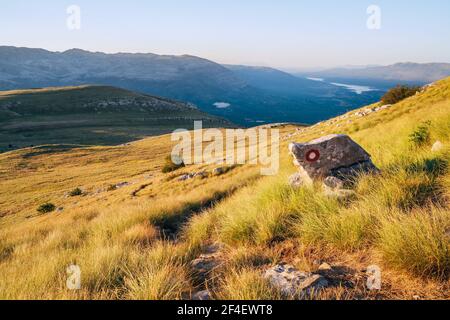 Marque de sentier de randonnée peinte sur la roche. Paysage vue de Sinjal ou Dinara (1831 m) montagne - le point le plus haut de la Croatie dans les Alpes Dinaric sur le bor Banque D'Images