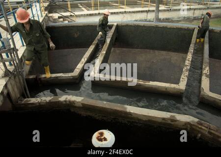 Jakarta, Indonésie. 18th juin 2021. Travailleurs effectuant le nettoyage d'entretien sur l'installation de traitement de l'eau de source, une partie du complexe de traitement de l'eau exploité par l'un des fournisseurs d'eau de Jakarta, Palyja, le propriétaire de la concession d'eau pour la partie ouest de la capitale indonésienne. Banque D'Images