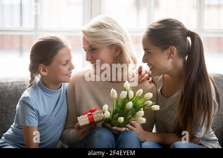 Enfant et jeune maman saluant grand-mère avec des cadeaux Banque D'Images