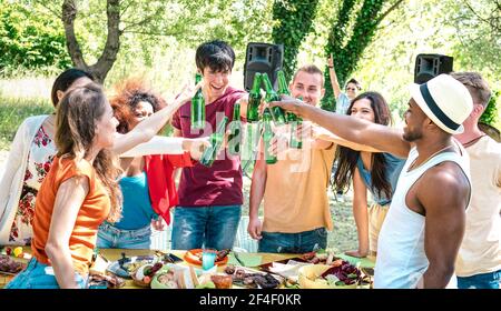 Joyeux amis multiraciaux en dégustant de la bière au barbecue dans le jardin de la fête - Concept d'amitié avec les gens qui s'amusent dans le camp d'été de l'arrière-cour Banque D'Images