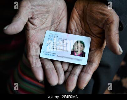 (210321) -- LHASSA, le 21 mars 2021 (Xinhua) -- Basang affiche sa carte d'identité chez elle dans le comté de Ngamring à Xigaze, dans la région autonome du Tibet du sud-ouest de la Chine, le 27 février 2021. Basang, né en 1936, avait l'habitude de grader des moutons pour un serf propriétaire de mendier sa vie avant la réforme démocratique de 1959. Elle a dû payer de la laine et du lait au propriétaire du séf comme taxe, et ne pouvait pas avoir assez de nourriture et de vêtements. 'L'hiver a été la saison la plus difficile. Il y avait huit personnes dans ma famille mais nous n'avions pas une paire de chaussures. » 'Paître les moutons et faire du travail de ferme pieds nus, j'envie vraiment les animaux avec des sabots.' Basang a dit wi Banque D'Images