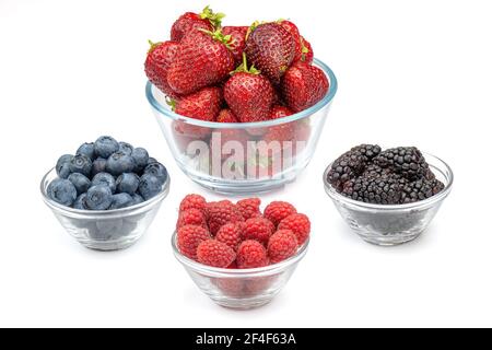 Baies fraîches fraises, framboises, mûres et bleuets dans des bols en verre isolés sur fond blanc. Baies dans un bol. Banque D'Images