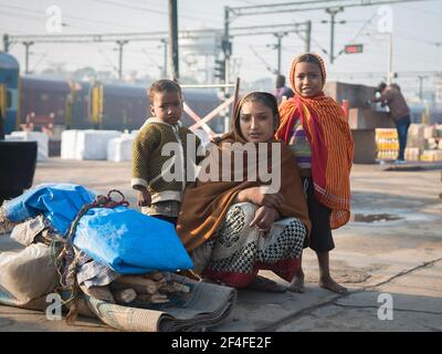 Varanasi. Inde. 11-02-2018. Mère avec deux enfants transportant des effets personnels à la gare de Varanasi. Banque D'Images