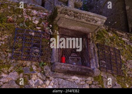 'Capilla de Almas' (Chapelle de Soul) : une petite chapelle dans UN mur en pierre avec des crânes et des bougies à l'intérieur Banque D'Images