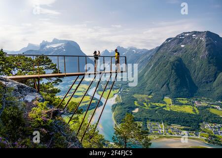 Randonneurs debout sur la plate-forme d'observation de Rampestreken, randonnée Romsdalseggen, rivière Rauma, Romsdalfjellene montagnes, Andalsnes, More og Romsdal, Norvège Banque D'Images