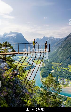 Randonneurs debout sur la plate-forme d'observation de Rampestreken, randonnée Romsdalseggen, rivière Rauma, Romsdalfjellene montagnes, Andalsnes, More og Romsdal, Norvège Banque D'Images