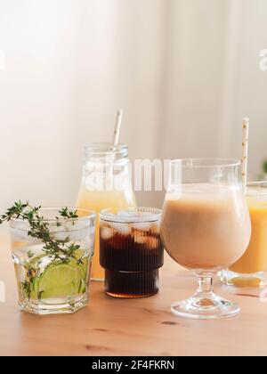 Boissons rafraîchissantes non alcoolisées dans des verres avec glace. Jus de fruits, limonades, café glacé, smoothies sur table en bois. Copier l'espace. Vue avant Banque D'Images