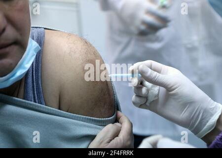 (210321) -- HÉBRON, le 21 mars 2021 (Xinhua) -- UN palestinien reçoit une dose de vaccin COVID-19 lors d'une campagne de vaccination au bureau du ministère de la Santé dans le village de Dura, en Cisjordanie, près d'Hébron, le 21 mars 2021. (Photo de Mamoun Wazwaz/Xinhua) Banque D'Images