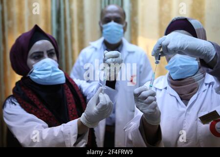 (210321) -- HÉBRON, le 21 mars 2021 (Xinhua) -- des agents de santé préparent le vaccin COVID-19 lors d'une campagne de vaccination au bureau du ministère de la santé dans le village de Dura, en Cisjordanie, près d'Hébron, le 21 mars 2021. (Photo de Mamoun Wazwaz/Xinhua) Banque D'Images