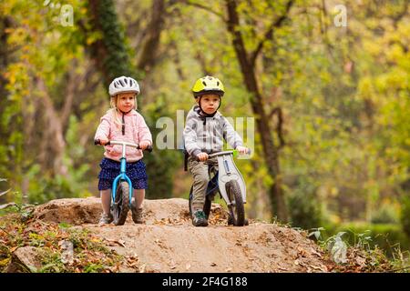 Deux petits amis assis sur des vélos d'équilibrage Banque D'Images