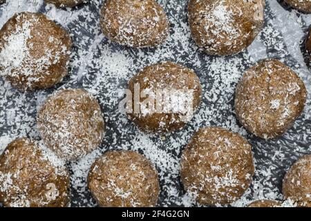 Des boules de dattes rapprochées de saupoudrées de noix de coco - vue du dessus photo d'en-cas sucré traditionnel Banque D'Images