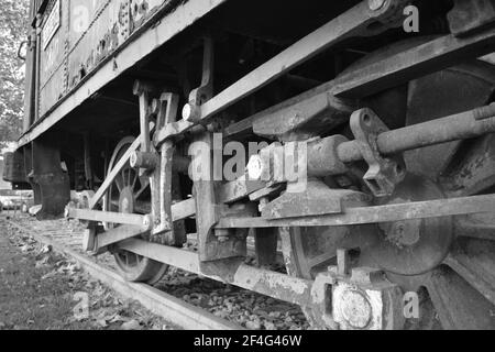 Ancien train à moteur à vapeur au parc de Córdoba. Andalucía, Espagne. Noir et blanc. Machine à vapeur rouillée laissée comme monument ou décoration dans le parc de Córdoba. Sombre. Banque D'Images