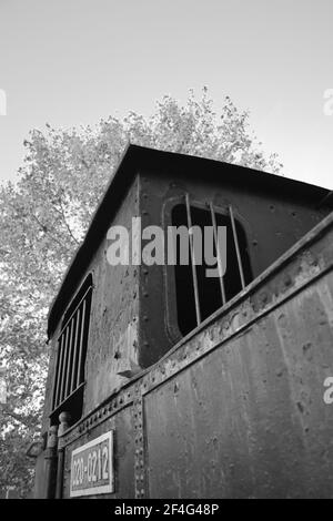 Ancien train à moteur à vapeur au parc de Córdoba. Andalucía, Espagne. Noir et blanc. Machine à vapeur rouillée laissée comme monument ou décoration dans le parc de Córdoba. Sombre. Banque D'Images