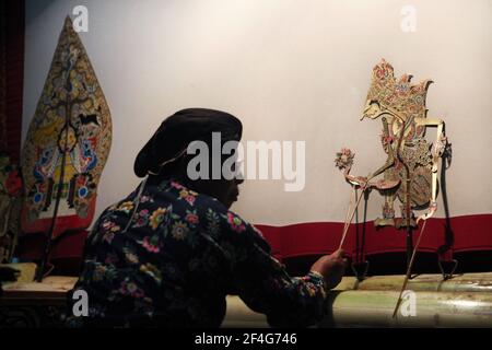 Le maître de marionnettes (dalang) interprète la représentation de wayang kulis « The Death of Kumbakarna » au Musée Sonobudoyo de Yogyakarta, dans le centre de Java, en Indonésie. Le théâtre traditionnel de marionnettes connu sous le nom de wayang kulis est répandu sur les îles de Java et Bali en Indonésie. Chaque exécution de wayang kulit se poursuit environ huit heures par nuit sans intermissions et un seul maître de marionnettes (dalang) conduit toutes les marionnettes projetées sur un écran en lin et les vocalise avec des voix différentes. Bien que l'Indonésie soit le pays musulman le plus peuplé du monde, les histoires et les personnages de wayang kuli Banque D'Images