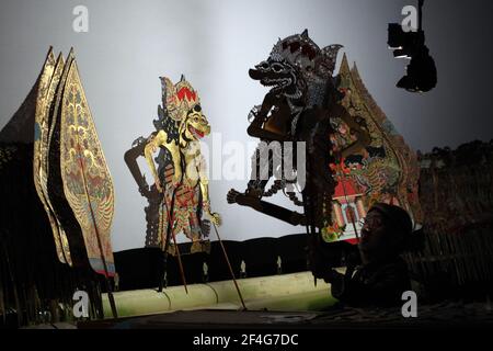 Maître de marionnettes (dalang) Manteb Sudharsono interprète la performance de wayang kulis 'Sudamala' au Sasono Hinggil Theatre de Yogyakarta, dans le centre de Java, en Indonésie. Le théâtre traditionnel de marionnettes connu sous le nom de wayang kulis est répandu sur les îles de Java et Bali en Indonésie. Chaque exécution de wayang kulit se poursuit environ huit heures par nuit sans intermissions et un seul maître de marionnettes (dalang) conduit toutes les marionnettes projetées sur un écran en lin et les vocalise avec des voix différentes. Bien que l'Indonésie soit le pays musulman le plus peuplé du monde, les histoires et les personnages de la voie Banque D'Images