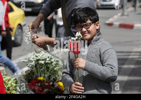 Naplouse. 21 mars 2021. Un garçon palestinien achète des fleurs à l'occasion de la Fête des mères dans la ville de Naplouse, en Cisjordanie, le 21 mars 2021. Credit: Ayman Nobani/Xinhua/Alamy Live News Banque D'Images