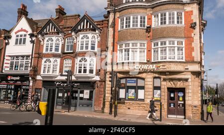 Epsom London, Royaume-Uni, 21 mars 2021, A Row of High Street Stores et Coral Bookmats avec des cyclistes sur la route Banque D'Images