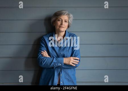 Une dame latine âgée sérieuse pose pour le portrait garde les bras croisés Banque D'Images