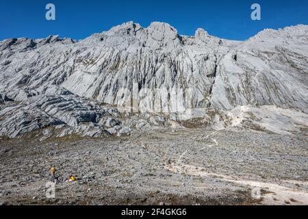 Un grimpeur mâle dans le camp de base de haute altitude de la Pyramide Carstensz (Puncak Jaya), un des plus exigeants grimpeurs dans une version des sept sommets Banque D'Images