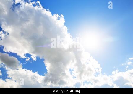 Soleil avec nuages blancs et fond bleu ciel. Nuages dans le ciel bleu. Le soleil de midi illumine l'espace. Banque D'Images