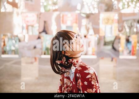portrait de fille asiatique avec chemise blanche et jupe regardant en plein air urbain style vintage film Banque D'Images