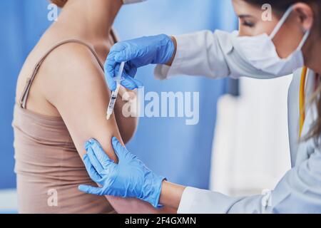 La patiente est vaccinée par un pédiatre Banque D'Images