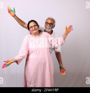 couple âgé d'âge ou d'âge indien célébrant le holi avec de la couleur Banque D'Images