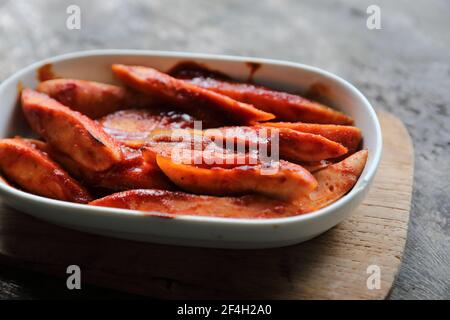 Morceaux de saucisse de currywurst allemand traditionnel avec sauce au curry arrière-plan en bois Banque D'Images