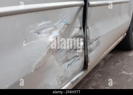 La carrosserie du véhicule est endommagée par accident. Voiture argent avec une grande bosselure sur le côté, ruinant deux portes Banque D'Images