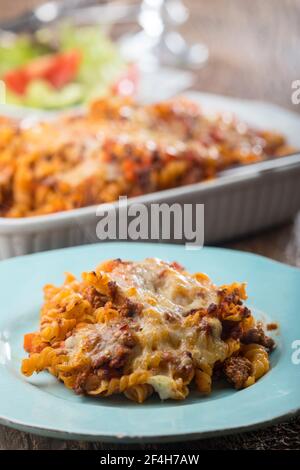 pâtes gratinées avec salade sur bois Banque D'Images
