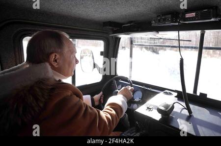 Tuva, Russie. 21 mars 2021. Le président russe Vladimir Poutine, à droite, conduit un véhicule à chenilles tout-terrain TTM-4902PS-10 lors d'une pause d'un week-end avec le ministre de la Défense Sergei Shoigu dans la forêt de taïga de Sibérie russe le 21 mars 2021 à Tuva, en Russie. Credit: Planetpix/Alamy Live News Banque D'Images