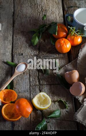 Du dessus des ingrédients assortis pour la mousse de mandarine disposés sur table en bois dans la cuisine Banque D'Images