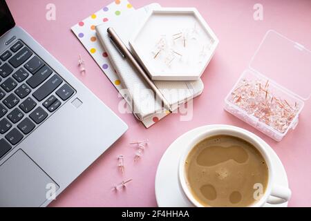 Le lieu de travail à la maison de Lady Blogger, une tasse de café et un clavier d'ordinateur portable sur une table rose Banque D'Images